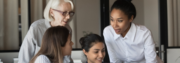 Multigenerational female employees working in a conference room together. 