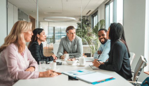 Five employees sitting around a conference table