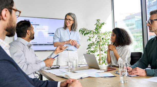 Female leader talking to employees in a conference room. 