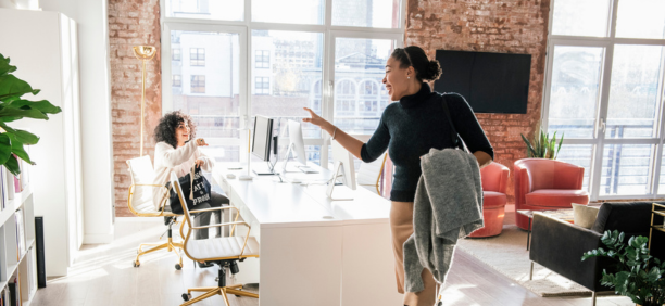 Woman waving goodbye to a coworker at the end of the work day.