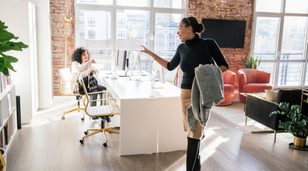 Woman waving goodbye to a coworker at the end of the work day.